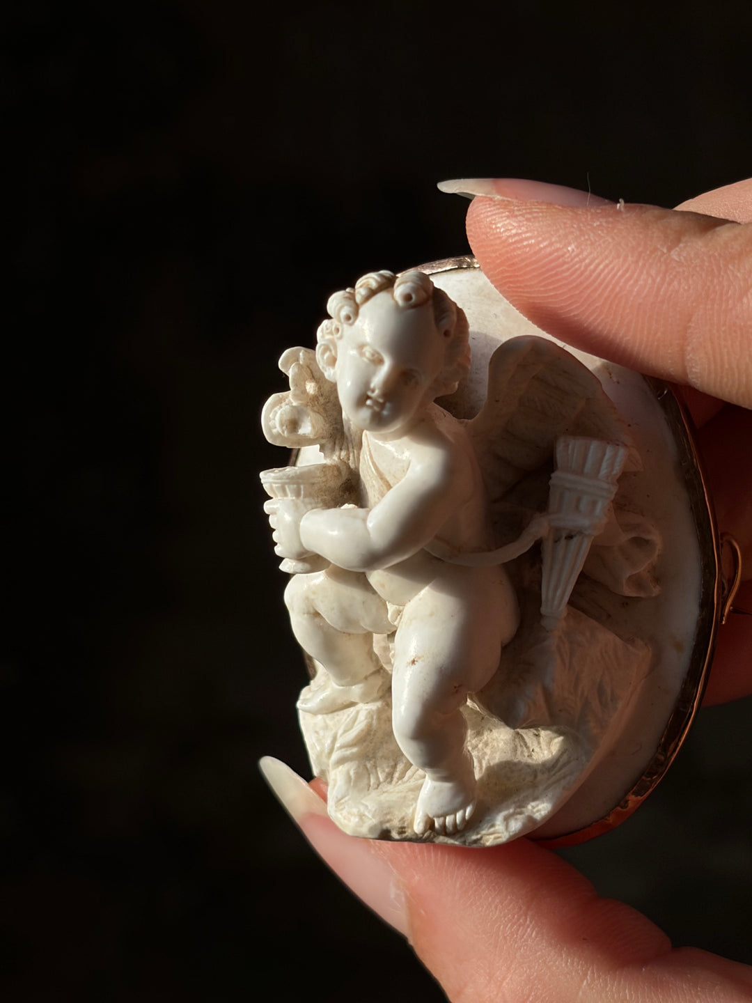 White lava Cupid cameo in 14ct gold, showing the goblet, wing and quiver in high relief.