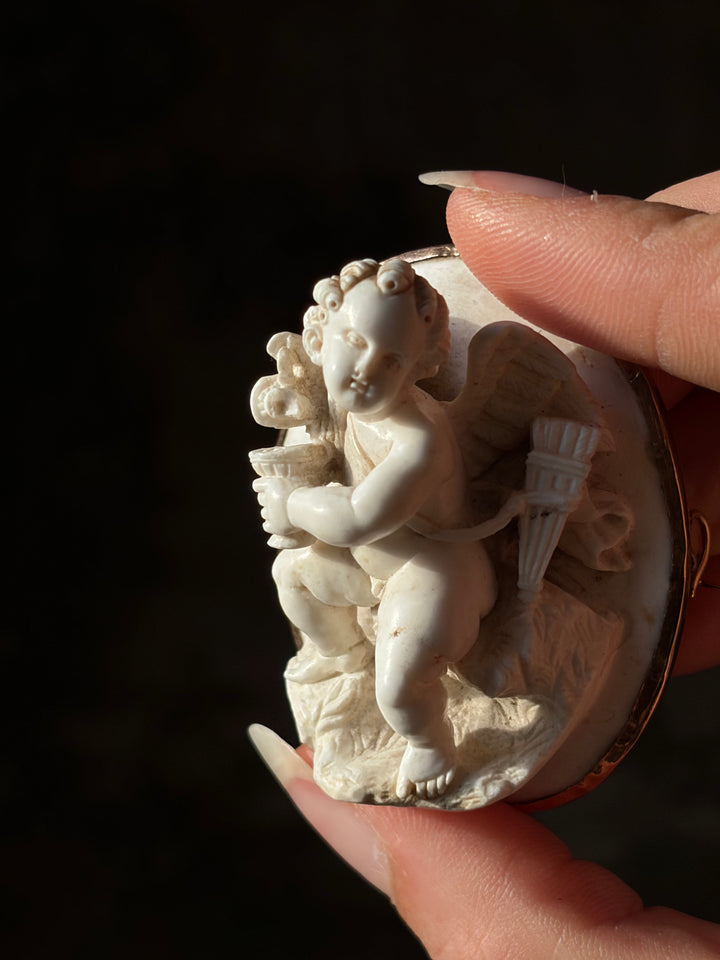 White lava Cupid cameo in 14ct gold, showing the goblet, wing and quiver in high relief.